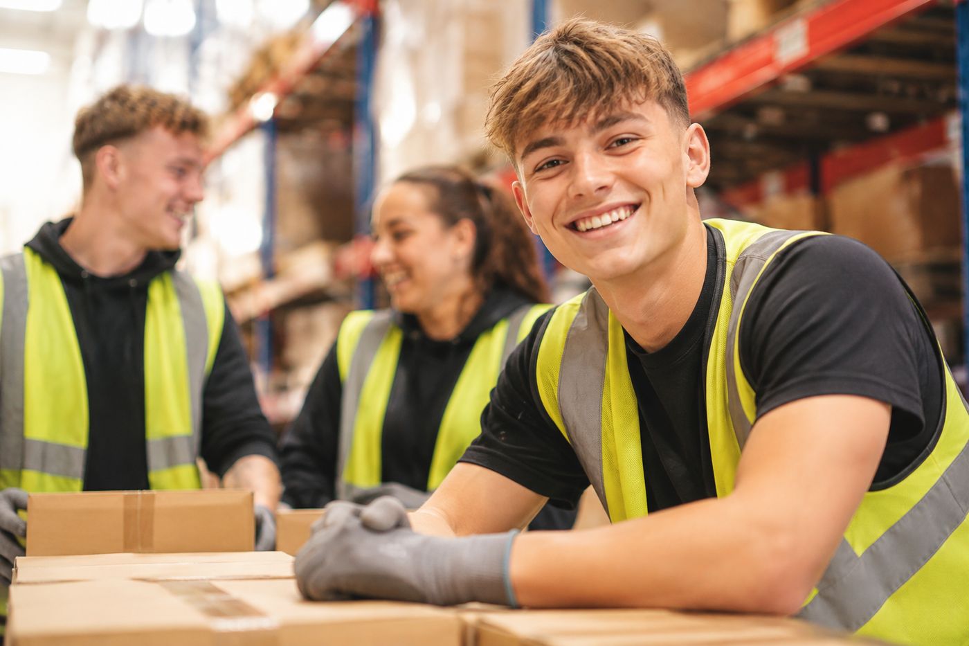 Teamly temporary workers in a warehouse Smiling Teamly temps in safety vests in a warehouse